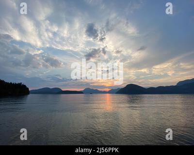 Sunset scene over mountains with reflection on water, near Thetis Island, Vancouver Island, British Columbia, Canada Stock Photo