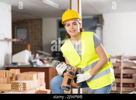 Female builder posing on indoor construction site Stock Photo