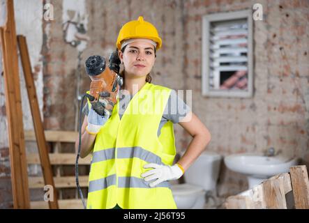 Female builder posing on indoor construction site Stock Photo
