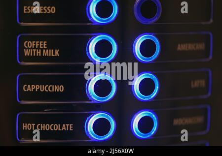 Buttons on a coffee machine indicating the type of drink glow blue Stock Photo