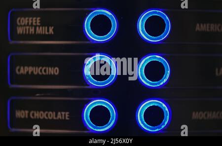 Buttons on a coffee machine indicating the type of drink glow blue Stock Photo