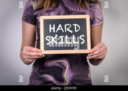 HARD SKILLS. Miniature chalk board with text in a woman's hands. Stock Photo
