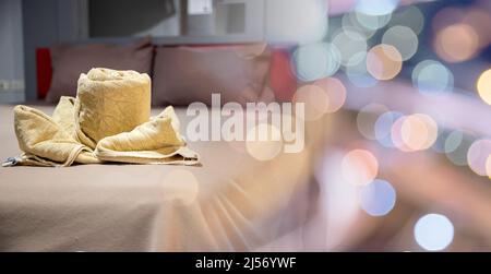 Yellow towel on bed decoration in bedroom interior, Freshly laundered fluffy towels, Towel in hotel room, Beautifully folded toiletries Stock Photo