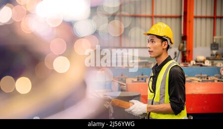 Worker man hand push remote control switch for overhead crane in factory, technician operating controlling the lift at factory industrial warehouse Stock Photo