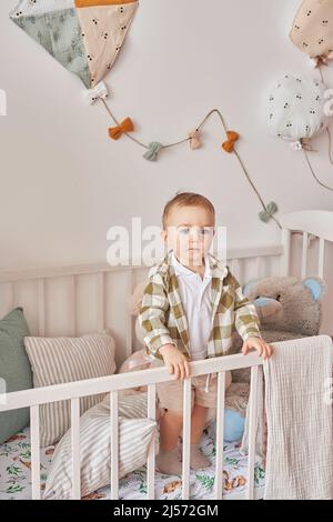 Baby boy in crib playing. Children's playroom. Educational toys. Early child development Stock Photo