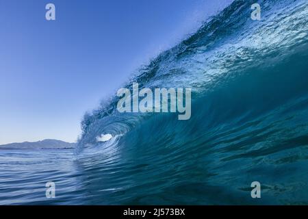A shore break wave in the early morning light at Ke Iki beach on the North Shore of Oahu. Stock Photo