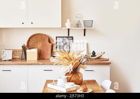 Cozy interior of bright loft style kitchen. White kitchen set. Kitchen accessories. Shelves and dishes. Good morning. Stylish luxury interior of studi Stock Photo