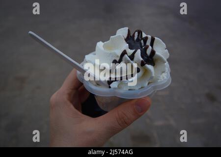 Whipped frozen yogurt or vanilla ice cream held in hand Stock Photo