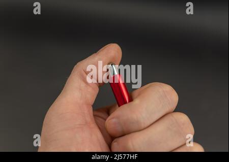 Close-up of a man's hand pressing a ballpoint pen button. The thumb of the left hand nervously presses the button. Stock Photo