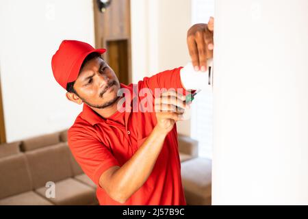 electrician fixing cctv or surveillance camera at home - concept of blue collar jobs, security and safety. Stock Photo