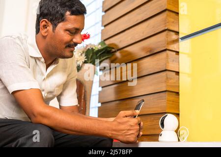 houseowner connect smart cctv camera on mobile phone at home - concept of safety, secure and smart home technology. Stock Photo