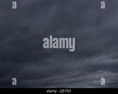 Clearly overcast skies. Dark, sinister clouds, dark blue in color, tightly cover the sky, blocking the light completely Stock Photo