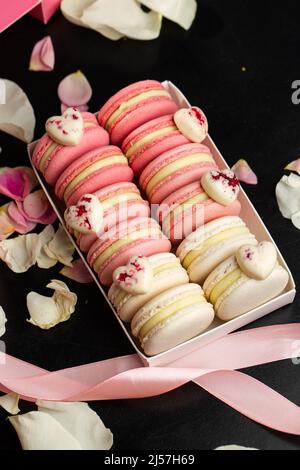 French macarons. Beautiful macaroons with heart decoration. Stylish arrangement sweet. Flat lay, top view. Macro photo Stock Photo