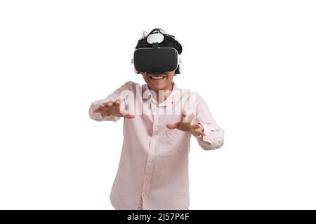 Young peruvian man laughing using virtual reality headset, isolated. Stock Photo