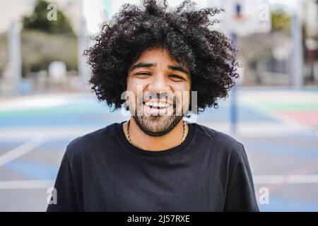 Happy African man smiling at camera inside basketball court - Focus on face Stock Photo