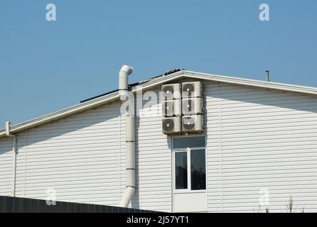 Ventilation systen on siding house construction with air compresors and chimney. Stock Photo