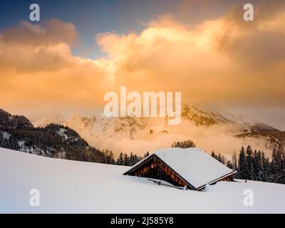 Snow-covered Priesbergalm in front of cloud-covered Watzmann, Berchtesgaden Alps, Berchtesgaden National Park, Schoenau am Koenigssee Stock Photo
