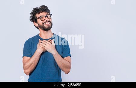 Attractive friendly and positive looking young man with a charming sincere smile feeling grateful Stock Photo