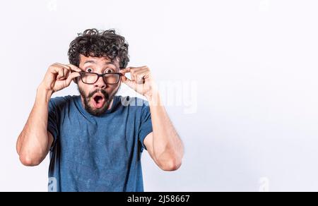 Surprised glasses man holding his glasses, Emotive young caucasian man staring through big glasses Stock Photo