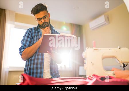 indian man sewing new collection in showroom in living room Stock Photo