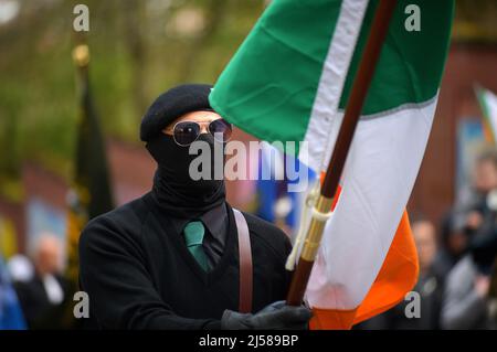 Masked men and women in paramilitary uniform at an Easter Masked man in paramilitary uniform carries Irish tricolour flag at an Easter Monday Dissident Republican parade in Derry, Northern Ireland 18 March 2022. ©George Sweeney / Alamy Stock Photo Stock Photo