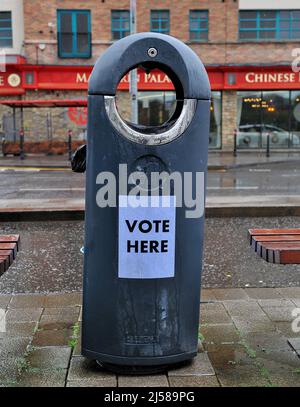 Sign reading Vote Here pasted to a rubbish collection bin in Derry, Northern Ireland during the 2022 Assembly elections. ©George Sweeney / Alamy Stock Photo Stock Photo