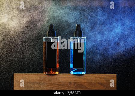 two bottles with yellow and blue liquid. two spray spraying cans on black background on wooden stand. mockup on cans, jars. selective focus. barbersho Stock Photo