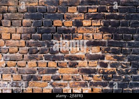 Close up photo of rustic and retro styled brick wall texture background. Old dark and black stained pattern design. Stock Photo