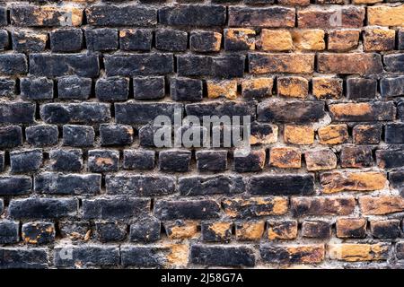 Close up photo of rustic and retro styled brick wall texture background. Old dark and black stained pattern design. Stock Photo