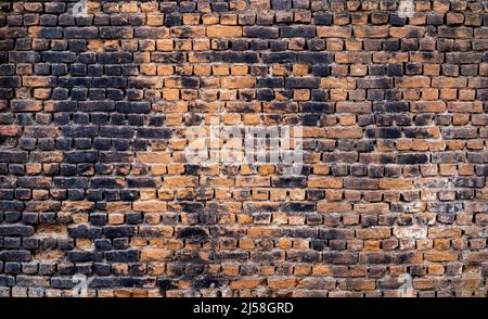 Close up photo of rustic and retro styled brick wall texture background. Old dark and black stained pattern design. Stock Photo