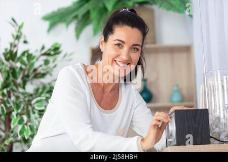 woman in the home putting music on the radio Stock Photo