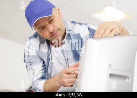 man assembling an air conditioning unit Stock Photo