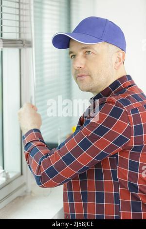 construction worker man install blinds Stock Photo