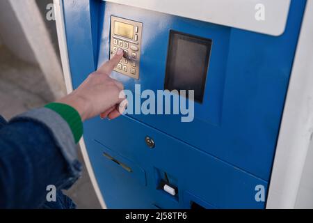 Woman hand typing pin code on ATM keyboard closeup Stock Photo