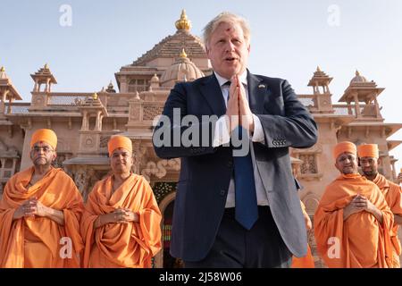 Shoeless Prime Minister Boris Johnson walks with sadhus, Hindu holymen, as he visits the Swaminarayan Akshardham temple in Gandhinagar, Ahmedabad, as part of his two day trip to India. Picture date: Thursday April 21, 2022. Stock Photo