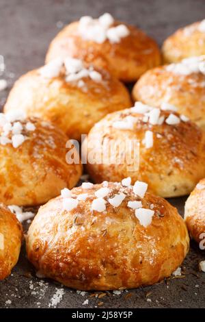 Bath buns classic English sweet pastry glazed with syrup, topped with caraway seeds and crushed sugar close-up on the table. Vertical Stock Photo