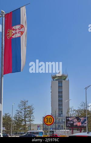 Belgrade, Serbia - April 13, 2022: Large and Tall Serbian Flag and Old Control Tower at Nikola Tesla Airport in Surcin. Stock Photo