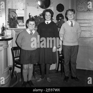 1962, historical, three schoolchildren in their uniform standing for their photo in the Padding Pub, Cheltenham, Gloucester, England, UK, with the younger boy wearing short trousers. Stock Photo