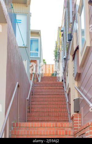 Perron staircase with bricks and metal handrailing at San Francisco, California. Staircase leading to a wooden gate in the middle of residential build Stock Photo