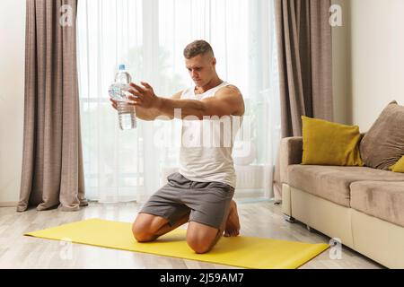 https://l450v.alamy.com/450v/2j59am7/young-athletic-man-using-bottles-of-water-like-an-alternative-of-dumbbells-for-home-workout-2j59am7.jpg