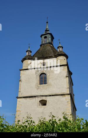 Large medieval stone tower with windows and crosses in several tiers. Below green vegetation Stock Photo