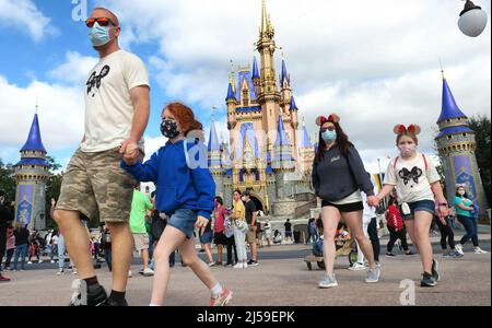 USA. 29th Jan, 2021. A masked family walks past Cinderella Castle in the Magic Kingdom, at Walt Disney World in Lake Buena Vista, Fla. Monday, December 21, 2020. Disneys Florida parks are currently operating at 35% capacity due to the Covid-19 pandemic. (Photo by Joe Burbank/Orlando Sentinel/TNS/Sipa USA) Credit: Sipa USA/Alamy Live News Stock Photo