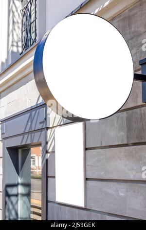 Mock up template. Blank round singboard and vertical white rectangular board of store, shop, restaurant, bar, office on classical style building wall Stock Photo