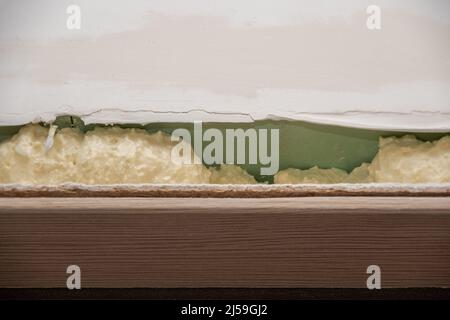 Installation of doors using polyurethane foam. Cylindrical foam. Yellow foam insulation. Mounting foam between wall and door Stock Photo