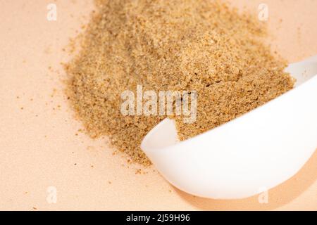 Mixture of dietary supplements. White can of dietary fiber and scoop on a beige background. Dietary herbal supplements, biologically active additives Stock Photo