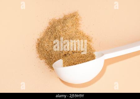 Mixture of biologically active additives for gut health. White scoop of dietary fiber on a beige background. Dietary herbal supplements. Stock Photo