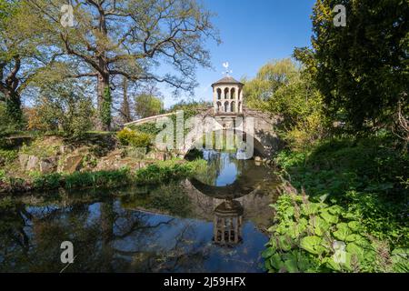 Dunsborough Park, a country estate in Surrey, England, UK, during April. Gardens with a lake and bridge. Stock Photo