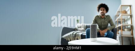 Young Man Using Wireless Speaker At Home Stock Photo