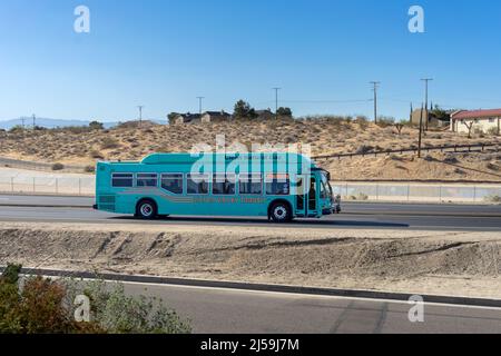 Apple Valley, CA, USA – April 20, 2022: A Victor Valley Transit bus, powered by natural gas, travels on Highway 18 in the Town of Apple Valley. Stock Photo