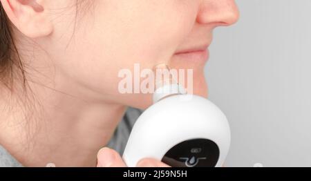 Close-up of using a facial blackhead removal machine. Cosmetic facial cleansing with a blackhead remover Stock Photo